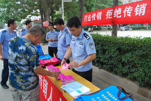 图为经侦大队民警与工商执法人员现场发放打击传销宣传材料